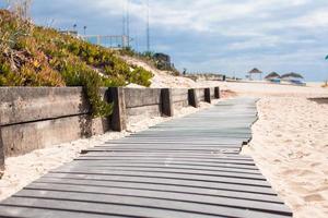 avvicinamento Visualizza di un' legna tavola camminare nel il spiaggia foto