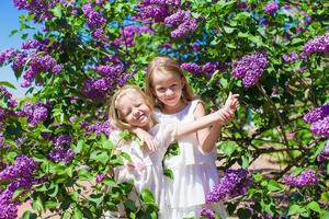 poco adorabile ragazze godendo bellissimo giorno nel fioritura giardino foto