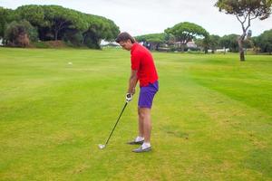 giovane che gioca a golf foto