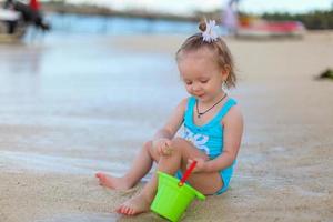 adorabile poco ragazza giocando con spiaggia giocattoli durante estate vacanza foto