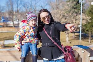 poco ragazza e madre a piedi su soleggiato giorno all'aperto foto