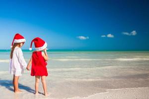 poco adorabile ragazze nel Santa cappelli durante spiaggia vacanza foto