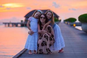 silhouette di giovane madre e Due sua poco ragazze a tramonto foto