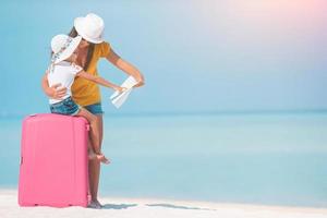 famiglia su il bianca spiaggia con Bagaglio foto