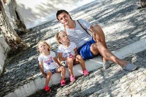 giovane padre e carino figlie seduta su strada nel vecchio greco cittadina foto