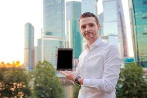 giovane caucasico uomo Tenere smartphone per attività commerciale opera. foto