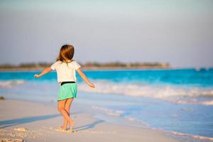 adorabile poco ragazza a spiaggia avendo un' lotto di divertimento nel superficiale acqua foto