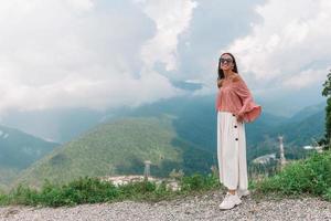 bellissimo contento giovane donna nel montagne nel il sfondo di nebbia foto