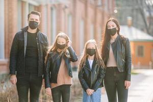 famiglia indossare un' maschera su un' sfondo di un' moderno costruzione, foto