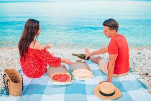 famiglia avendo un' picnic su il spiaggia foto