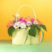 bellissimo fiori mazzo nel regalo leggero verde carta Borsa con nastri su giallo verde sfondo. foto