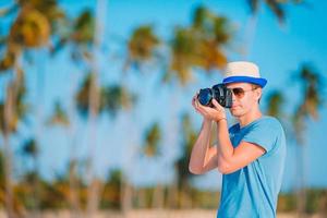 giovane uomo fotografato a telecamera su tropicale spiaggia foto