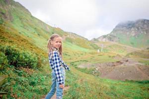 bellissimo contento poco ragazza nel montagne nel il sfondo di nebbia foto