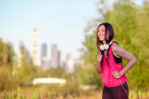 giovane donna sorridente facendo esercizi sportivi all'aperto foto