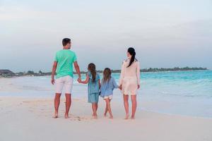 giovane famiglia con Due bambini su spiaggia vacanza foto