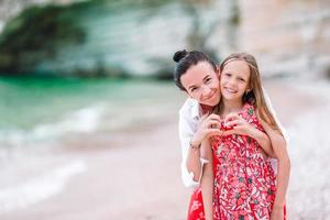 bellissimo madre e figlia a il spiaggia godendo estate vacanza. foto