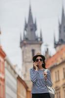 contento giovane donna nel cappello su il strada di europeo città. foto