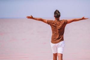 turista uomo camminare su un' rosa sale lago su un' soleggiato estate giorno. foto