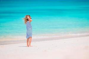 adorabile poco ragazza a spiaggia su sua estate vacanza foto