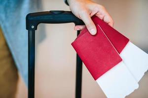 primo piano dell'uomo che tiene i passaporti e la carta d'imbarco all'aeroporto foto