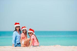 adorabili bambine e giovane madre sulla spiaggia bianca tropicale foto