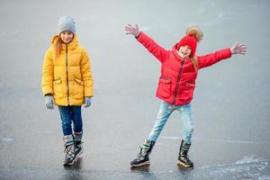 adorabile poco ragazze pattinando su il pista di pattinaggio foto