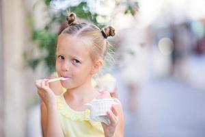 adorabile poco ragazza mangiare gelato all'aperto a estate. carino ragazzo godendo vero italiano gelato vicino gelateria nel Roma foto