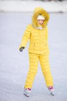 adorabile poco ragazza andando pattinare nel inverno neve giorno all'aperto foto