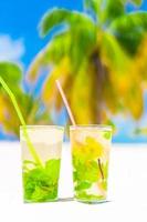 Due freddo gustoso mohito cocktail su il bianca sabbioso spiaggia foto