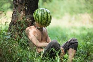 ragazzo con un' anguria anziché di testa foto