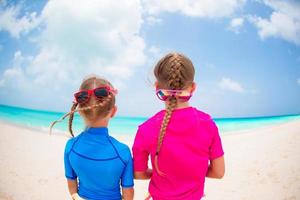 bambini avendo divertimento a tropicale spiaggia giocando insieme a superficiale acqua foto