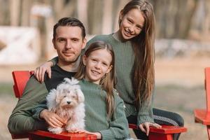 madre e figlia giocando con cane all'aperto foto