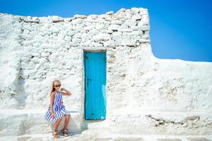 adorabile poco ragazza a vecchio strada di tipico greco tradizionale villaggio foto