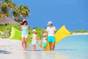 giovane famiglia di quattro persone in vacanza al mare foto