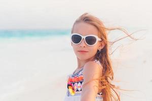 adorabile poco ragazza a piedi lungo bianca sabbia caraibico spiaggia foto