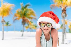 adorabile poco ragazza nel Santa cappello durante Natale spiaggia vacanza foto