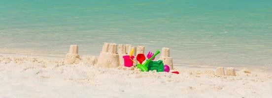 castello di sabbia a bianca spiaggia con plastica bambini giocattoli foto