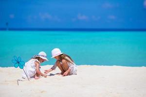 poco adorabile ragazze disegno immagine su bianca spiaggia foto