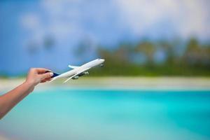 piccolo bianca miniatura di un aereo su sfondo di turchese mare foto