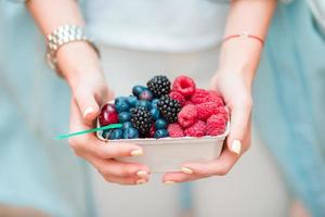 avvicinamento frutti di bosco frutta a femmina mani. mirtilli, lamponi, fragole, ciliegie e more su il mercato. giardinaggio, agricoltura, raccogliere e foresta concetto. foto