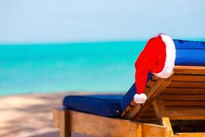 sole lettino con Santa cappello a bellissimo tropicale spiaggia con bianca sabbia e turchese acqua. Perfetto Natale vacanza foto