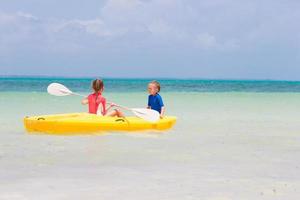 bambine adorabili godendo kayak in kayak giallo foto
