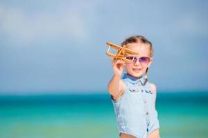 contento ragazzo giocando con giocattolo aereo su il spiaggia. foto