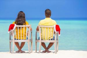 giovane coppia nel Santa cappelli rilassante su tropicale spiaggia durante Natale vacanza foto