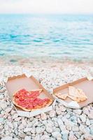 fresco Pizza su il spiaggia sfondo di il mare foto