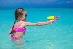 contento poco ragazza giocando a spiaggia durante caraibico vacanza foto