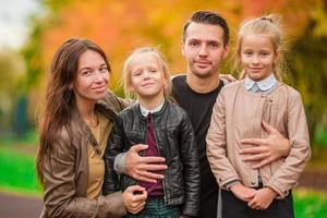 giovane famiglia con poco bambini nel autunno parco su soleggiato giorno foto