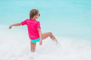 carino poco ragazza a spiaggia durante caraibico vacanza foto