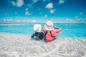 adorabile poco ragazze giocando nel all'aperto nuoto piscina su vacanza foto