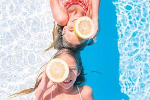 poco ragazze copertura occhi con Limone metà vicino occhi su sfondo nuoto piscina foto